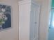 Hallway with a tall white linen closet and artwork on the wall near a doorway at 5632 Holiday Park Blvd, North Port, FL 34287