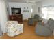 Cozy living room with hardwood floors, comfortable seating, and a decorative entertainment center at 5632 Holiday Park Blvd, North Port, FL 34287