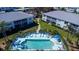 Aerial view of a condo community with a pool, surrounded by tropical landscaping and buildings at 5725 Greenwood Ave # 3104, North Port, FL 34287