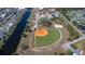 Aerial view of a well-maintained baseball field in a residential community with a canal and nearby amenities at 5725 Greenwood Ave # 3104, North Port, FL 34287