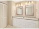 Bright bathroom with a double vanity, granite countertop, and elegant framed mirrors at 623 Oak Hill Cir # 28, Sarasota, FL 34232