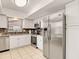 Well-lit kitchen features stainless steel appliances, white cabinetry, and tiled flooring at 623 Oak Hill Cir # 28, Sarasota, FL 34232