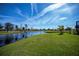 Manicured backyard lawn meets waterfront, offering a peaceful view at 855 Rotonda Cir, Rotonda West, FL 33947
