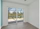 Bedroom featuring sliding glass door with backyard and lake views, light gray floors, and white walls at 855 Rotonda Cir, Rotonda West, FL 33947