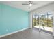 Bedroom with aqua accent wall, sliding glass door, and view of the lush backyard and water at 855 Rotonda Cir, Rotonda West, FL 33947