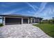 Beautiful single-story home featuring a large paver driveway and an attached three-car garage at 855 Rotonda Cir, Rotonda West, FL 33947