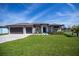 Beautiful single-story home featuring a large yard and an attached three-car garage at 855 Rotonda Cir, Rotonda West, FL 33947