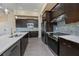 Contemporary kitchen featuring dark wood cabinets, white countertops, and stainless steel appliances at 855 Rotonda Cir, Rotonda West, FL 33947