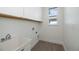 Bright laundry room with white cabinets, light gray flooring, a utility sink, and a window at 855 Rotonda Cir, Rotonda West, FL 33947