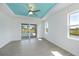 Bright bedroom with tray ceiling, fan and view of pool, patio and waterfront through glass sliding doors at 855 Rotonda Cir, Rotonda West, FL 33947