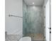 Bathroom shower with gray tiled walls, mosaic stone floor, and glass partition, and silver hardware at 855 Rotonda Cir, Rotonda West, FL 33947