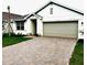 Charming single-Gathering home featuring an attached two-car garage and a beautifully brick-paved driveway at 9516 Turtle Grass Cir, Punta Gorda, FL 33950