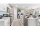 Well-lit kitchen featuring stainless steel appliances, white cabinetry, quartz countertops and tile flooring at 9522 Turtle Grass Cir, Punta Gorda, FL 33950