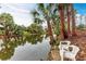 Backyard view of a tranquil canal with two chairs on the bank, perfect for relaxing at 1052 Hinton St, Port Charlotte, FL 33952