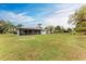 Large backyard featuring a lush lawn, mature trees, and a screened-in patio at 1052 Hinton St, Port Charlotte, FL 33952
