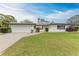 Charming single-story home featuring a well-maintained lawn, paved walkway and two-car garage at 1052 Hinton St, Port Charlotte, FL 33952