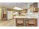 Eat-in kitchen features wood cabinetry, white appliances, and counter seating at 1052 Hinton St, Port Charlotte, FL 33952