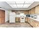View of a kitchen with wood cabinets, white appliances, laminate countertops, and wood-look floors at 1052 Hinton St, Port Charlotte, FL 33952