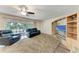 Living room featuring a ceiling fan, sliding glass doors, and a large entertainment center at 1052 Hinton St, Port Charlotte, FL 33952