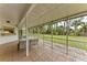 Back patio area surrounded by beautiful trees with a large, plush yard at 1052 Hinton St, Port Charlotte, FL 33952