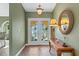 Welcoming foyer featuring tiled floors, a decorative table, and a round mirror, enhancing the home's charm at 1225 Neapolitan Rd, Punta Gorda, FL 33983