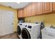 Efficient laundry room with ample cabinet space, modern washer and dryer units, and a utility sink at 1225 Neapolitan Rd, Punta Gorda, FL 33983