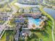 A beautiful aerial view of a community clubhouse with a pool, tennis courts, and lush landscaping, perfect for resort-style living at 12285 Canavese Ln, Venice, FL 34293