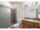 This bathroom features a glass-enclosed shower, granite countertop, and wood cabinets at 12285 Canavese Ln, Venice, FL 34293