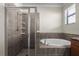 Bathroom with a glass-enclosed shower and soaking tub at 12285 Canavese Ln, Venice, FL 34293