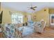 Cozy living room featuring wood-look flooring, a ceiling fan, and ample natural light at 1333 Mendavia Ter, North Port, FL 34286