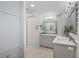Bright bathroom with gray vanity, ample storage, modern lighting, and elegant marble flooring at 1334 Via Milanese, Punta Gorda, FL 33950