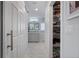 Hallway view of a bathroom with dual vanities and a large walk-in closet for ample storage at 1334 Via Milanese, Punta Gorda, FL 33950