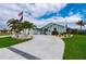 Beautiful single-Gathering home with a circular driveway, lush lawn, and decorative palm trees at 1334 Via Milanese, Punta Gorda, FL 33950