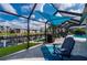 Outdoor entertaining area with a large pool, covered patio, grill, and canal access at 1334 Via Milanese, Punta Gorda, FL 33950