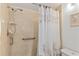 Bathroom shower with neutral tiling, grab bar, and a shower curtain with seashell print at 1344 Rock Dove Ct # D102, Punta Gorda, FL 33950