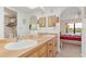 Bathroom featuring a long wood countertop, double sinks, arched mirror, and access to the bedroom at 1344 Rock Dove Ct # D102, Punta Gorda, FL 33950