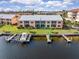 Waterfront condo with boat docks, manicured lawn, and views of the building's facade from the water at 1344 Rock Dove Ct # D102, Punta Gorda, FL 33950