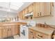 Well-lit kitchen features light wood cabinetry, white appliances, and spacious countertops and backsplash at 1344 Rock Dove Ct # D102, Punta Gorda, FL 33950