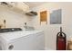 Laundry room features washer and dryer, overhead shelving for storage, and wall decor at 1344 Rock Dove Ct # D102, Punta Gorda, FL 33950