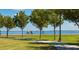 Scenic park view with paved path, lush green grass, trees, and waterfront in the distance at 1344 Rock Dove Ct # D102, Punta Gorda, FL 33950