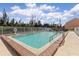 Community pool with lake view, a ladder for access, and beautiful landscaping at 1344 Rock Dove Ct # D102, Punta Gorda, FL 33950