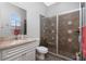 Well-lit bathroom featuring a tile shower with glass door and a vanity with marble countertop at 1417 Carswell St, Port Charlotte, FL 33953