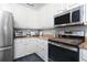 Kitchen features stainless steel appliances, light-colored cabinets, and stone countertops at 1417 Carswell St, Port Charlotte, FL 33953