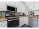 Kitchen features stainless steel appliances, light-colored cabinets, and stone countertops at 1417 Carswell St, Port Charlotte, FL 33953
