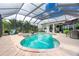 Inviting screened-in pool area with a spa, seating, and clear blue water at 1417 Carswell St, Port Charlotte, FL 33953