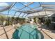 Inviting screened-in pool area with a spa, seating, and clear blue water at 1417 Carswell St, Port Charlotte, FL 33953