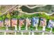 Aerial view highlighting several homes with screened pools, a lake, and well-manicured lawns at 1616 Palmetto Palm Way, North Port, FL 34288