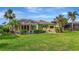 Lovely backyard with a screened-in pool, lush lawn, and tropical landscaping offering privacy at 1616 Palmetto Palm Way, North Port, FL 34288