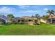 Spacious backyard featuring a screened-in pool, lush green lawn, and mature tropical landscaping at 1616 Palmetto Palm Way, North Port, FL 34288