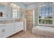 Well-lit primary bathroom with double vanity, soaking tub, and tiled walk-in shower at 1616 Palmetto Palm Way, North Port, FL 34288